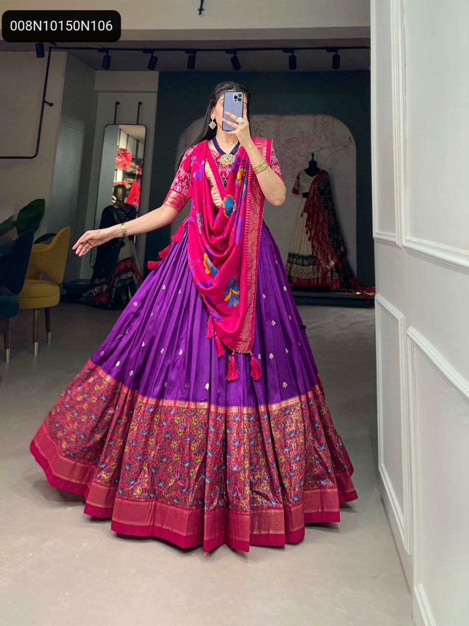 A woman twirling in a voluminous purple Tussar Silk lehenga with a contrasting pink printed dupatta, highlighting the magnificent flair and detailed craftsmanship.