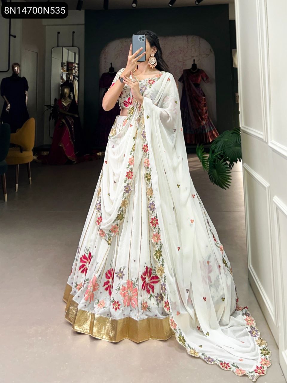 Full body shot of a model showcasing the TRENDBUY white georgette lehenga choli with vibrant floral embroidery and a gold border.