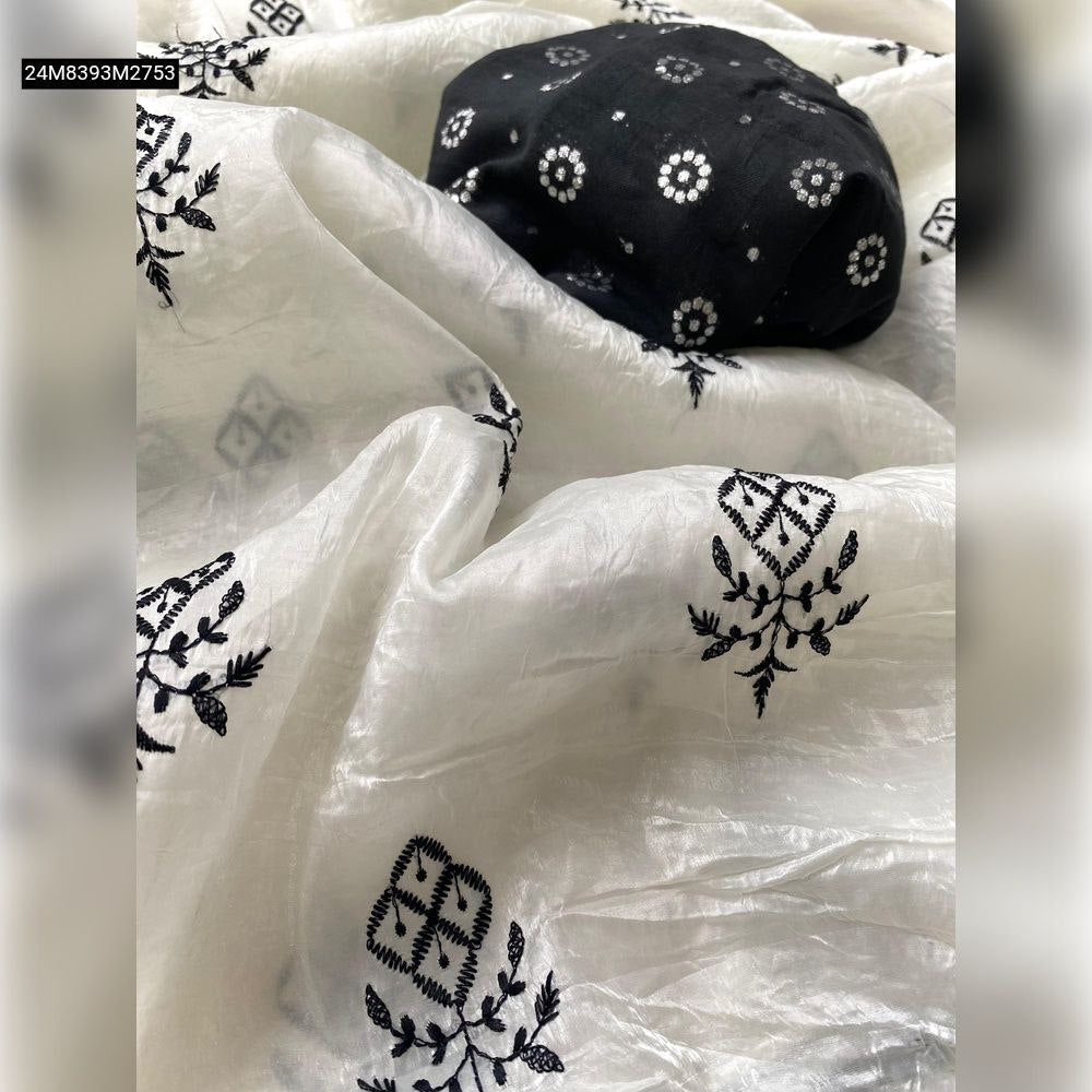 Close-up view of the TRENDBUY white paper crush saree fabric, highlighting the textured material and intricate black thread butti embroidery, with the contrasting black Benarasi blouse piece folded nearby.