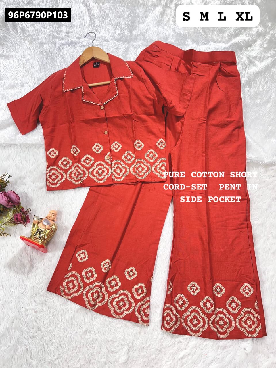 Red cotton co-ord set with white embroidery on short top and palazzo pants, displayed flat on a white textured surface.