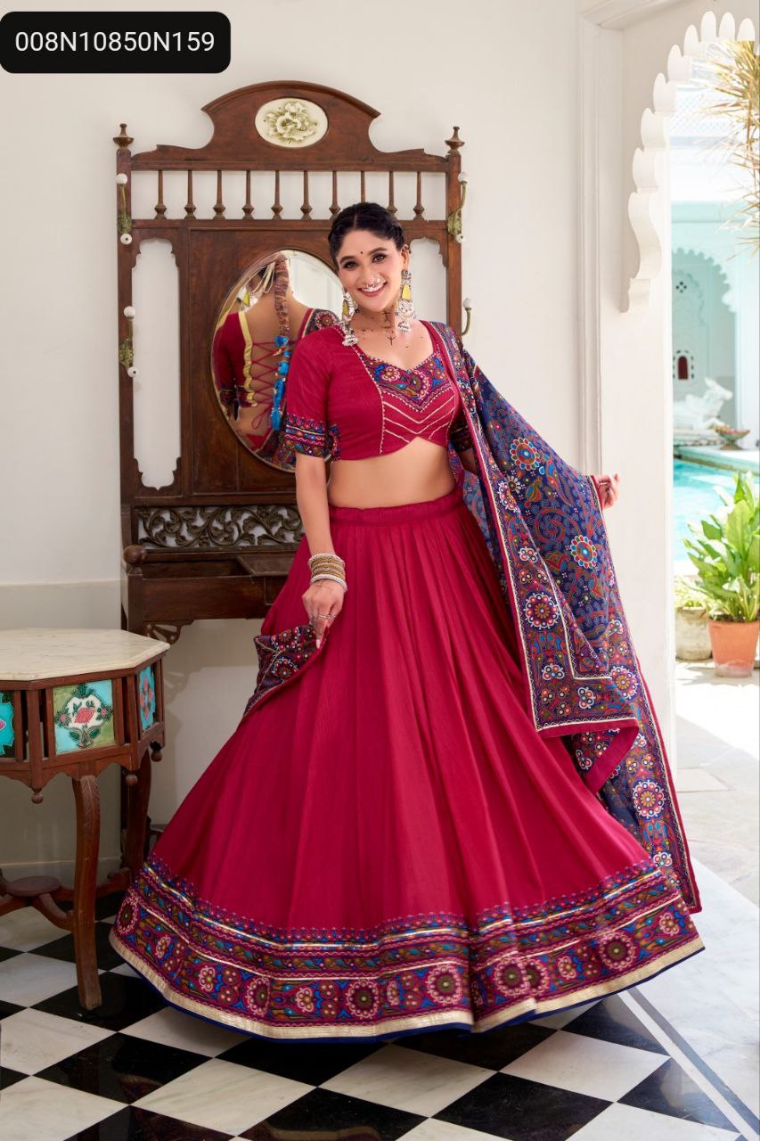 TRENDBUY Red Tasar Silk Gamthi Print Lehenga Choli Set. Full length model shot, standing and smiling, displaying the complete vibrant red outfit with embroidered blouse and a matching printed dupatta, in an elegant setting.