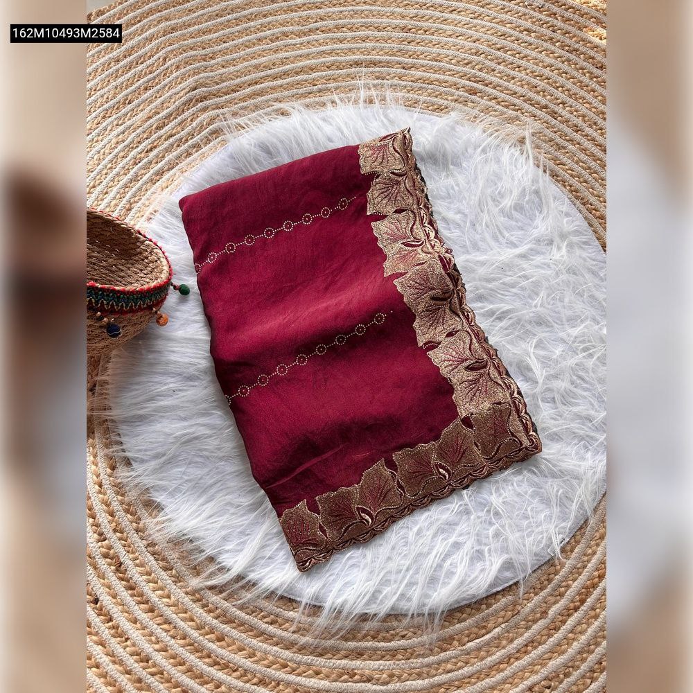 TRENDBUY Wine Red Fandy Satin Silk Saree, neatly folded with a prominent golden leaf embroidered border and subtle diamond lines, displayed on a white fur mat and woven rug.