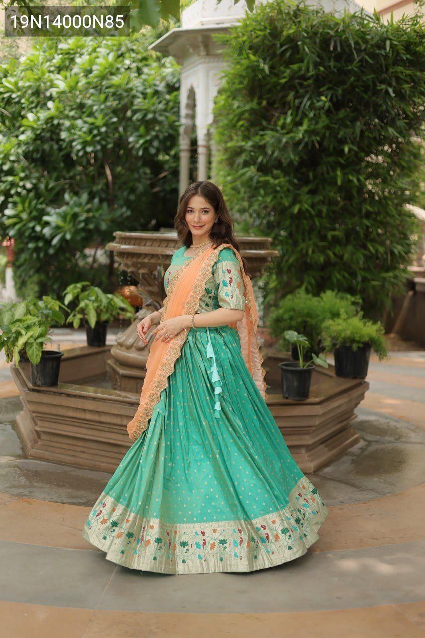 Model showcasing TRENDBUY Pista Cosmos Jequard Lehenga Choli with an orange Russian silk embroidered dupatta, full length shot in an outdoor garden setting.
