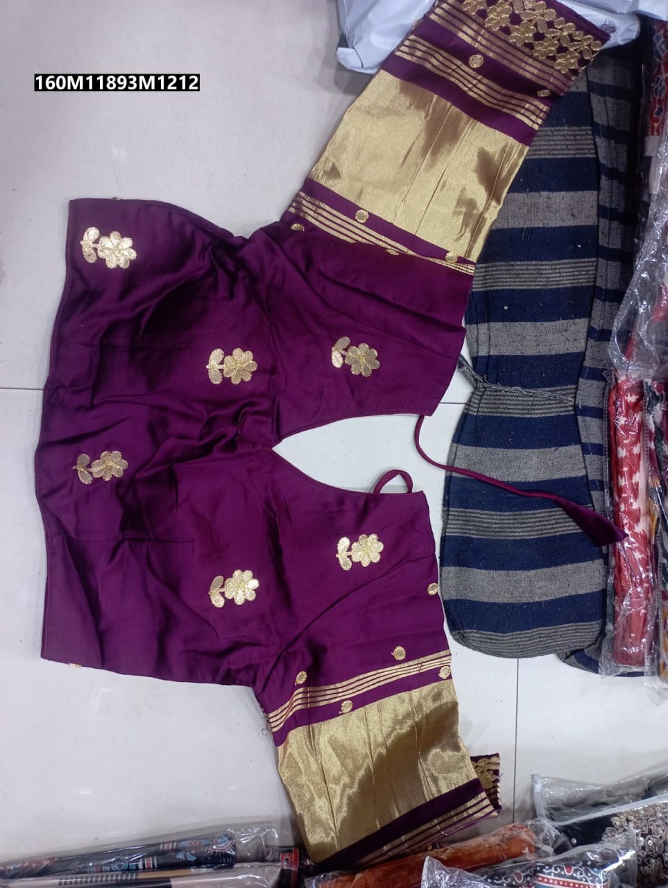 Close-up of intricate gold Gota Patti embroidery on the wine-colored silk blouse