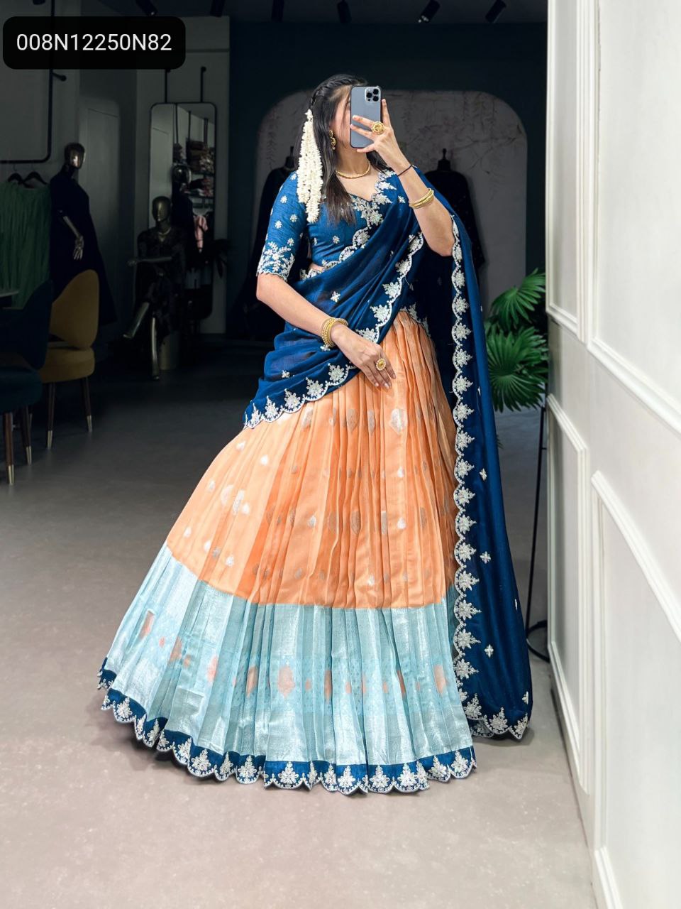 Captivating full length shot of a woman wearing the TRENDBUY Midnight Blue & Peach Lehenga Choli, with a deep blue embroidered top and a flowing peach and aqua layered lehenga.