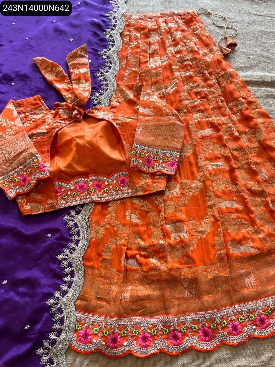 Full flat lay of TRENDBUY orange dola silk lehenga and blouse with a vibrant purple chinnon silk dupatta, detailed zari weaving, and scalloped embroidery, perfect for festive wear.