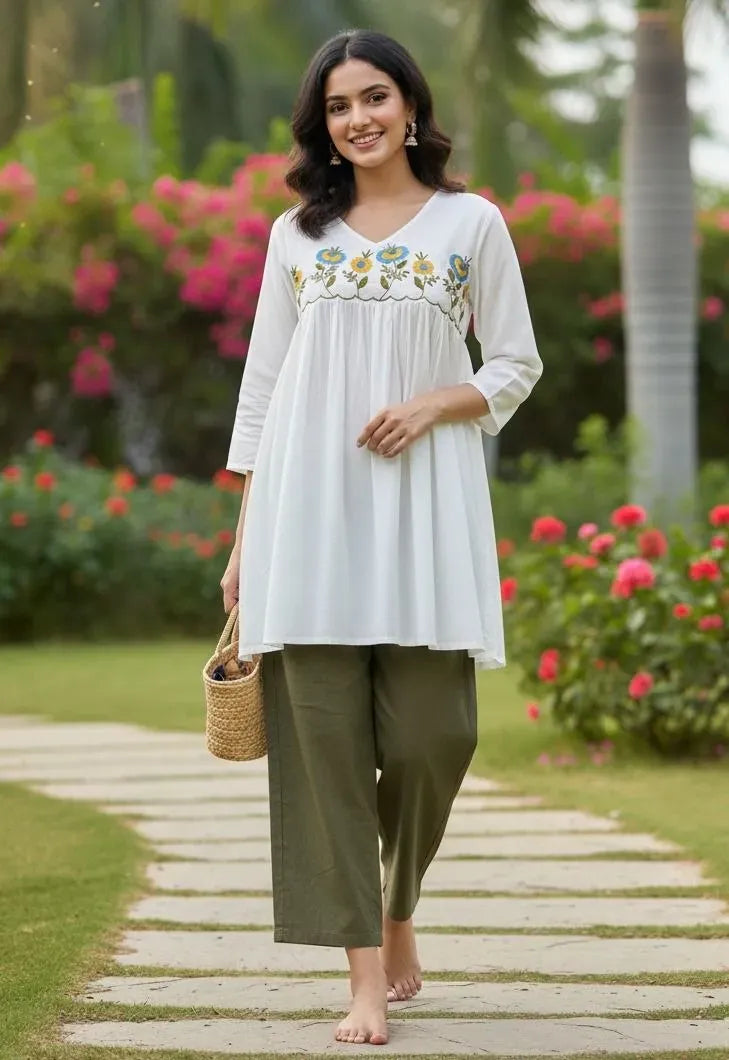 Full length view of model wearing white tunic and olive pants outdoors
