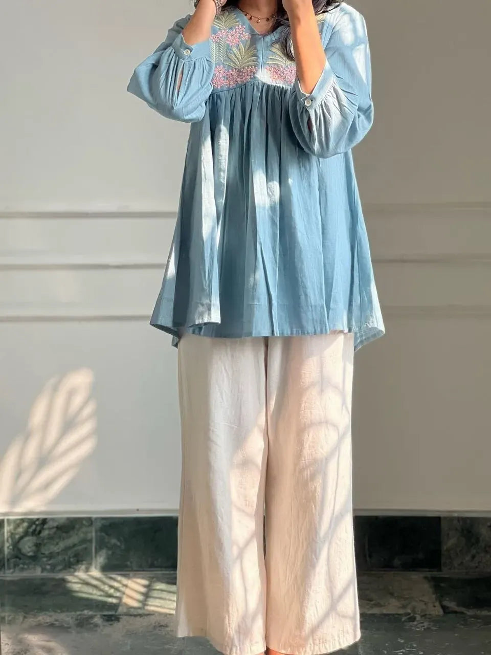 Woman wearing light blue pure cotton embroidered kurti with white palazzo