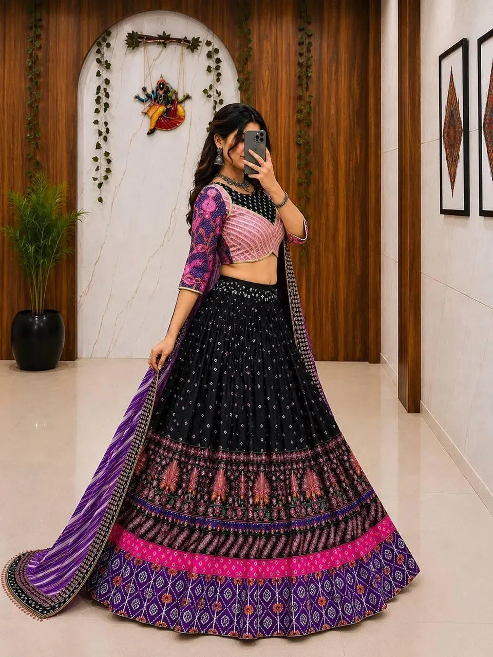Full view of woman wearing black and purple digital print lehenga choli indoors