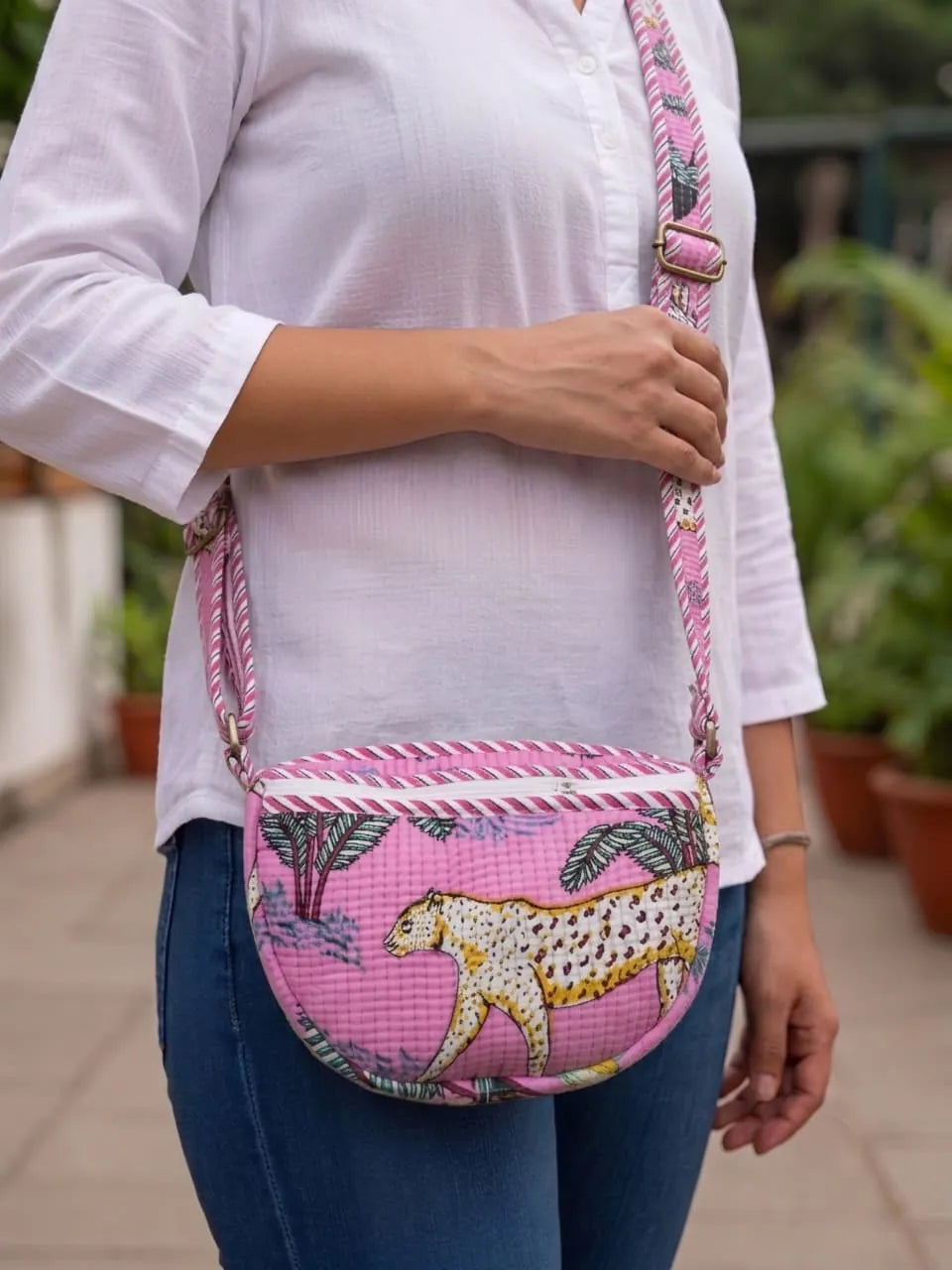 Pink hand block printed quilted sling bag with cheetah motif worn by model