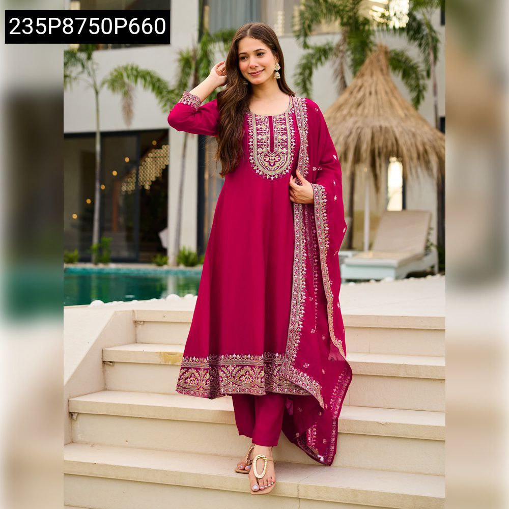 Woman posing elegantly in a magenta Vichitra silk embroidered Anarkali suit set, with a pool and tropical background.