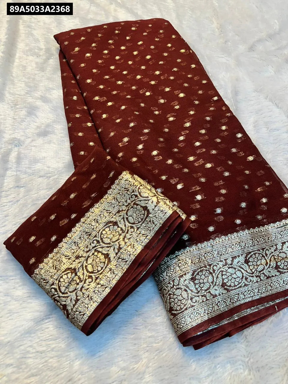 TRENDBUY Viscose Georgette Saree with intricate golden motifs and matching running blouse piece, beautifully folded on a white background.