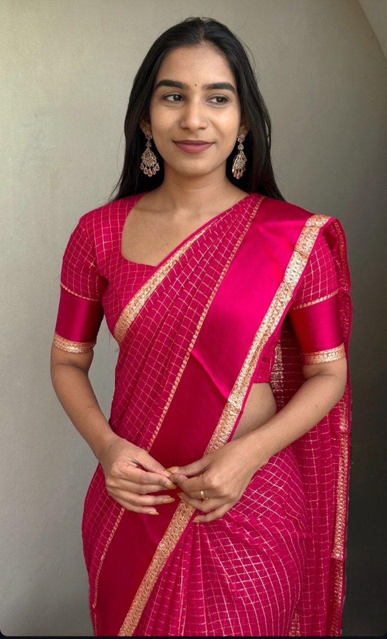Woman modeling a vibrant Rani Pink Viscose Georgette Saree with gold Jari weaving from TRENDBUY.