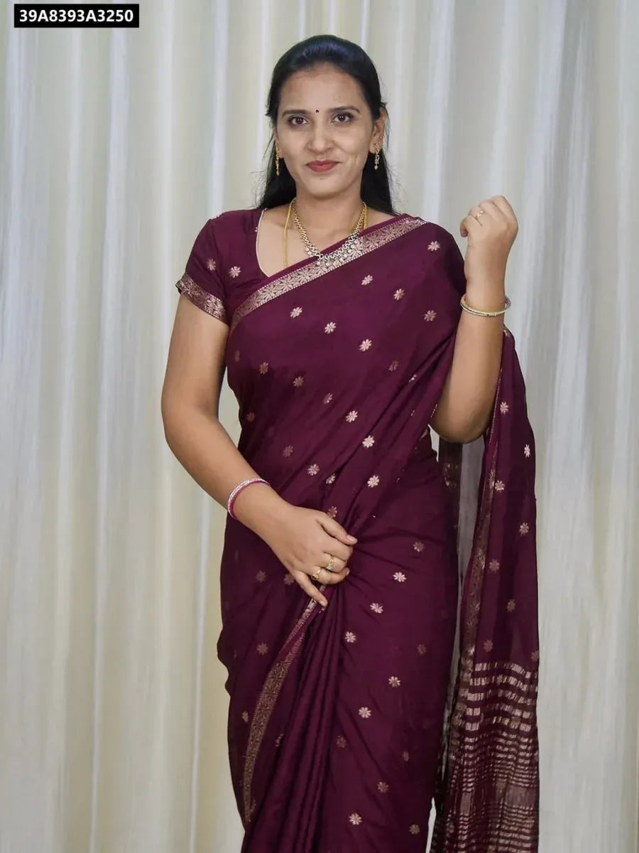 Model wearing a Burgundy pure viscose jacquard weaving saree with golden floral border and motifs, front-facing.