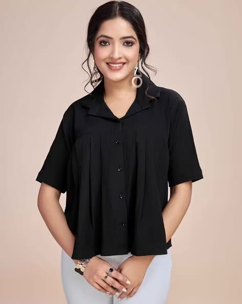Woman wearing a black pleated shirt type top, perfect for casual elegance.