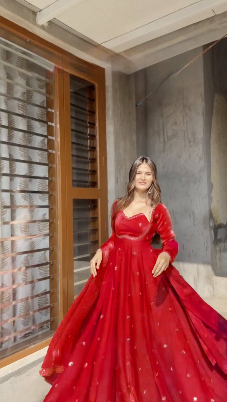 Model wearing a vibrant Cherry Red Anarkali suit, full body outdoor shot