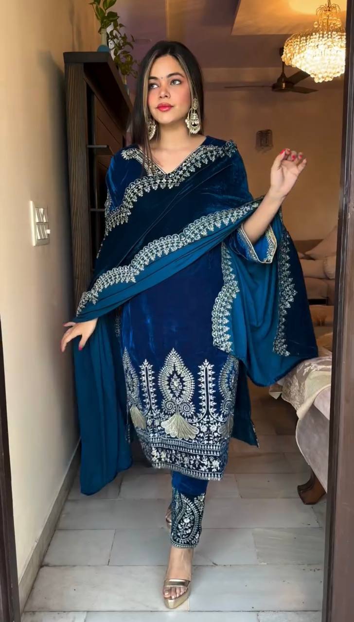 Woman posing elegantly in a blue designer velvet suit set with heavy silver embroidery, perfect for party wear.
