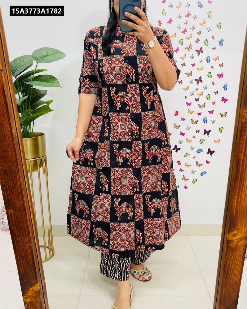 Woman posing in black and red digital print co-ord set with camel patterns, mirror selfie