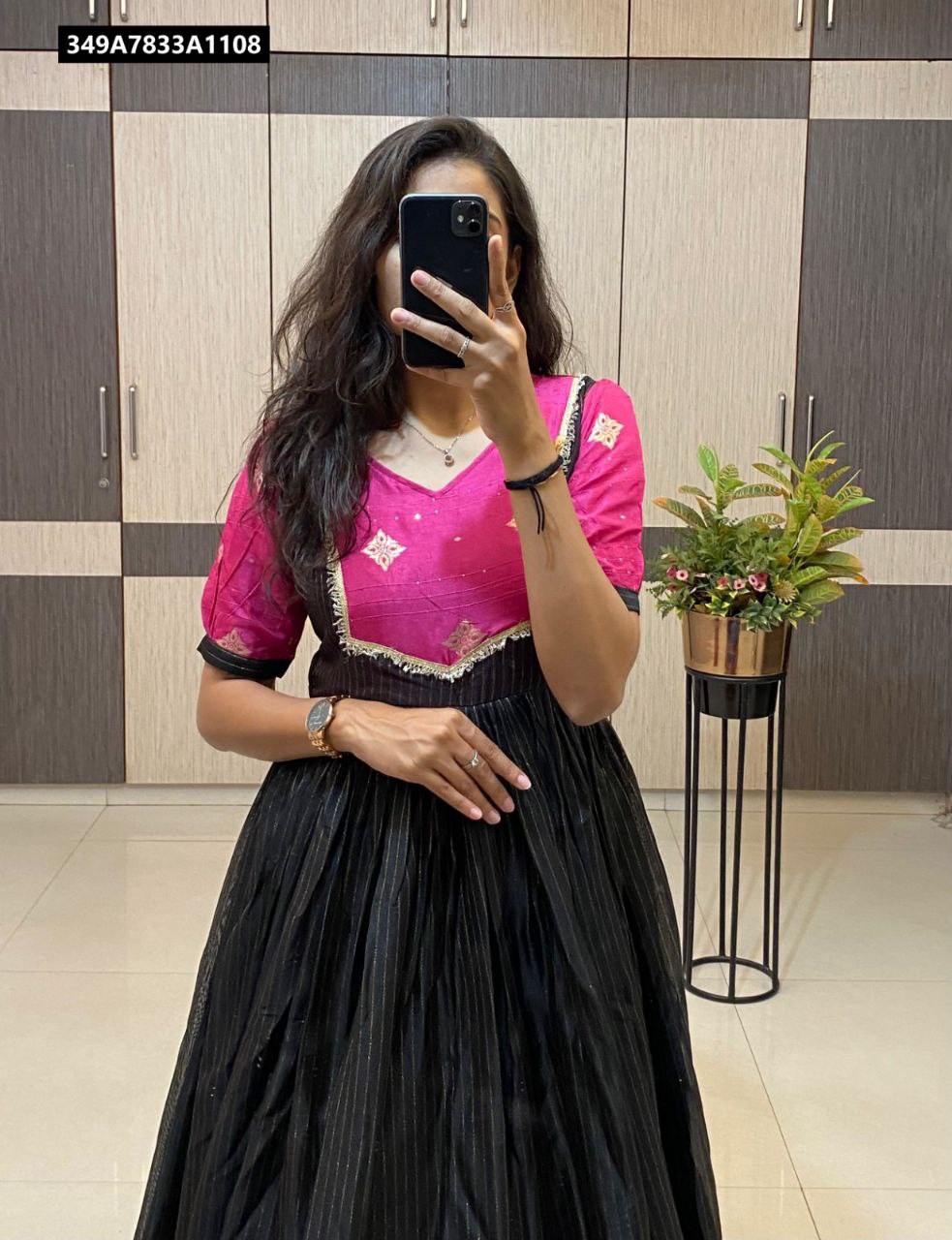 Woman in black and fuchsia Dola silk gown with jacquard border and fancy neck, front view.