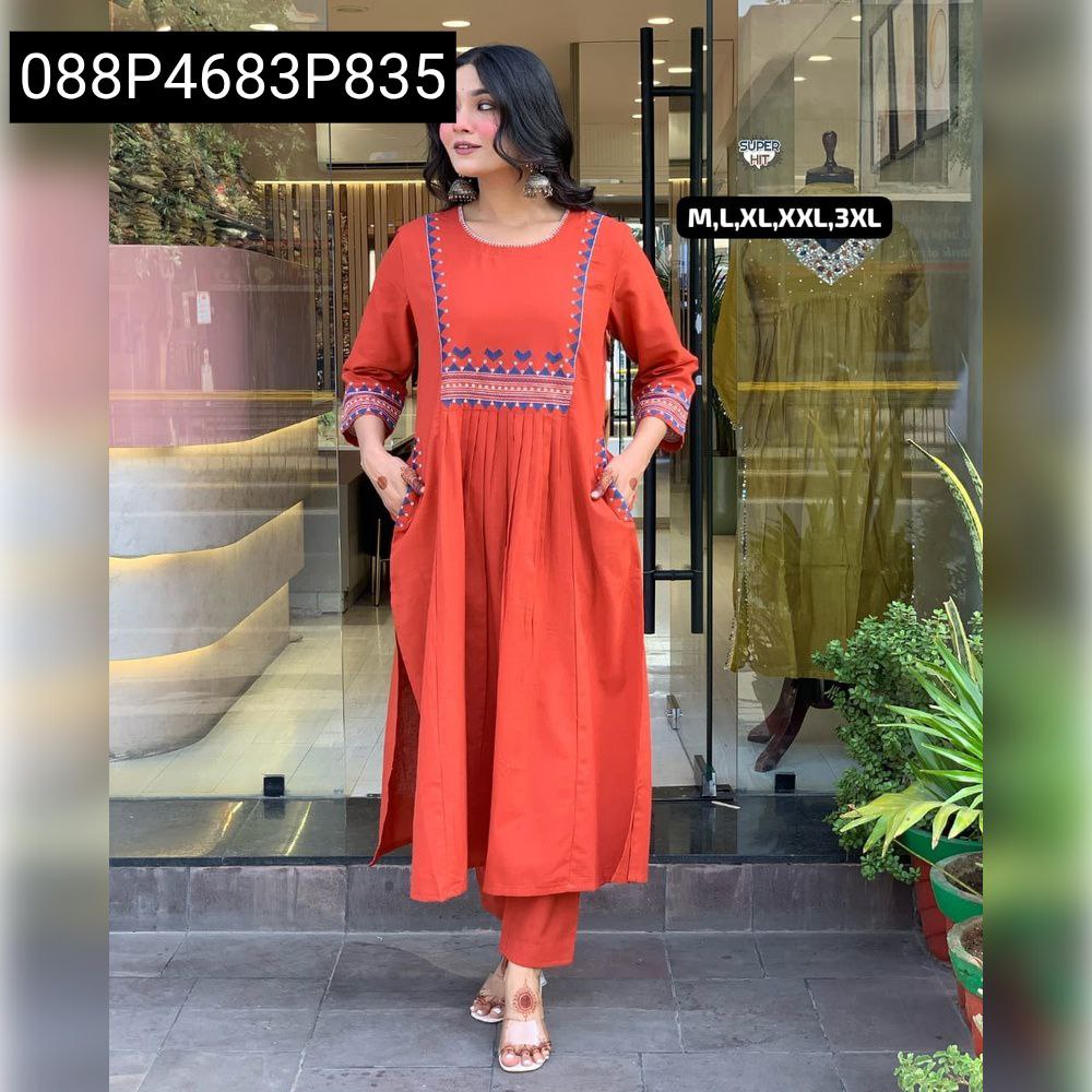 Model wearing an orange/rust embroidered cotton kurti pant set, full body shot.