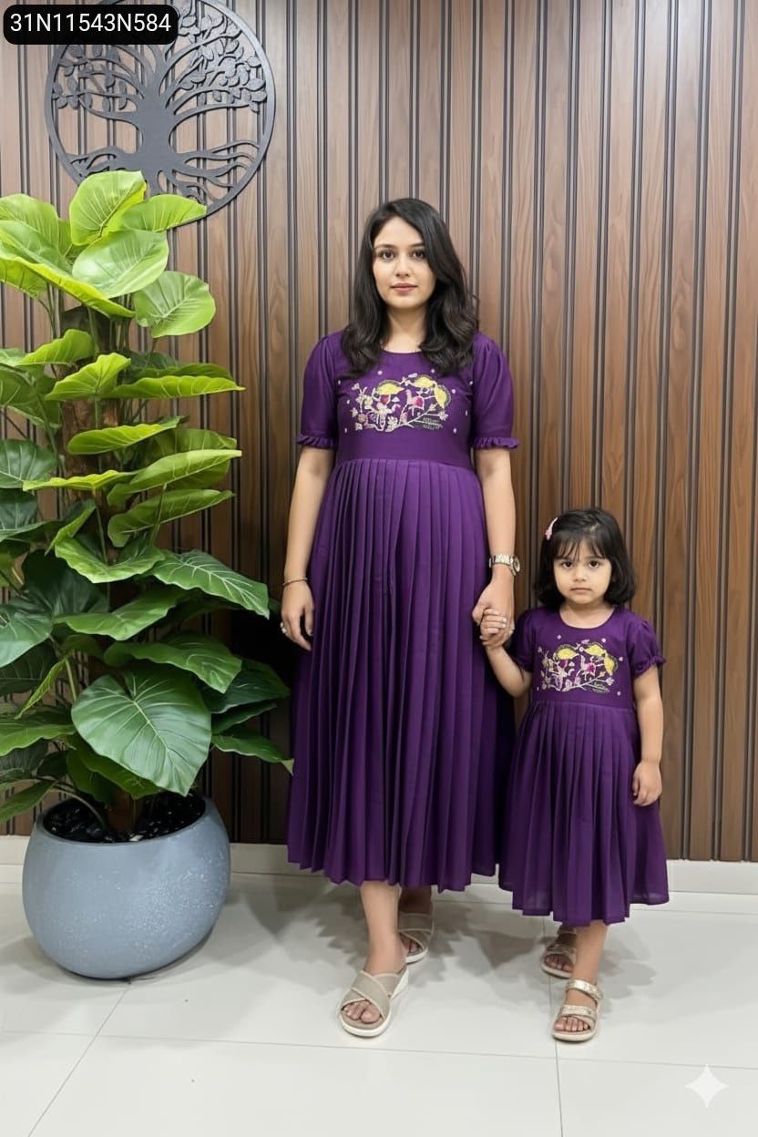 Mother and daughter in matching Lavender embroidered pleated gowns, posing elegantly.