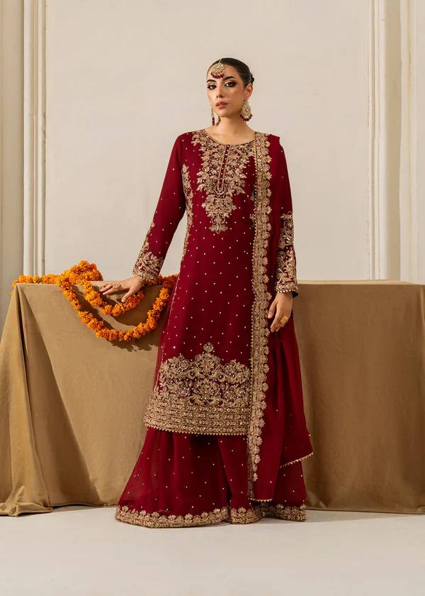 Full shot of model posing elegantly in a maroon embroidered viscose velvet plazo suit, front view.