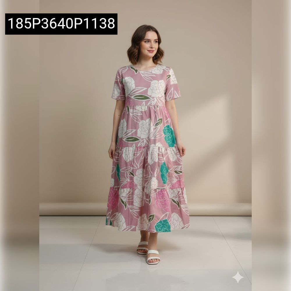 Woman standing confidently in a blush pink floral tiered maxi dress, front view.