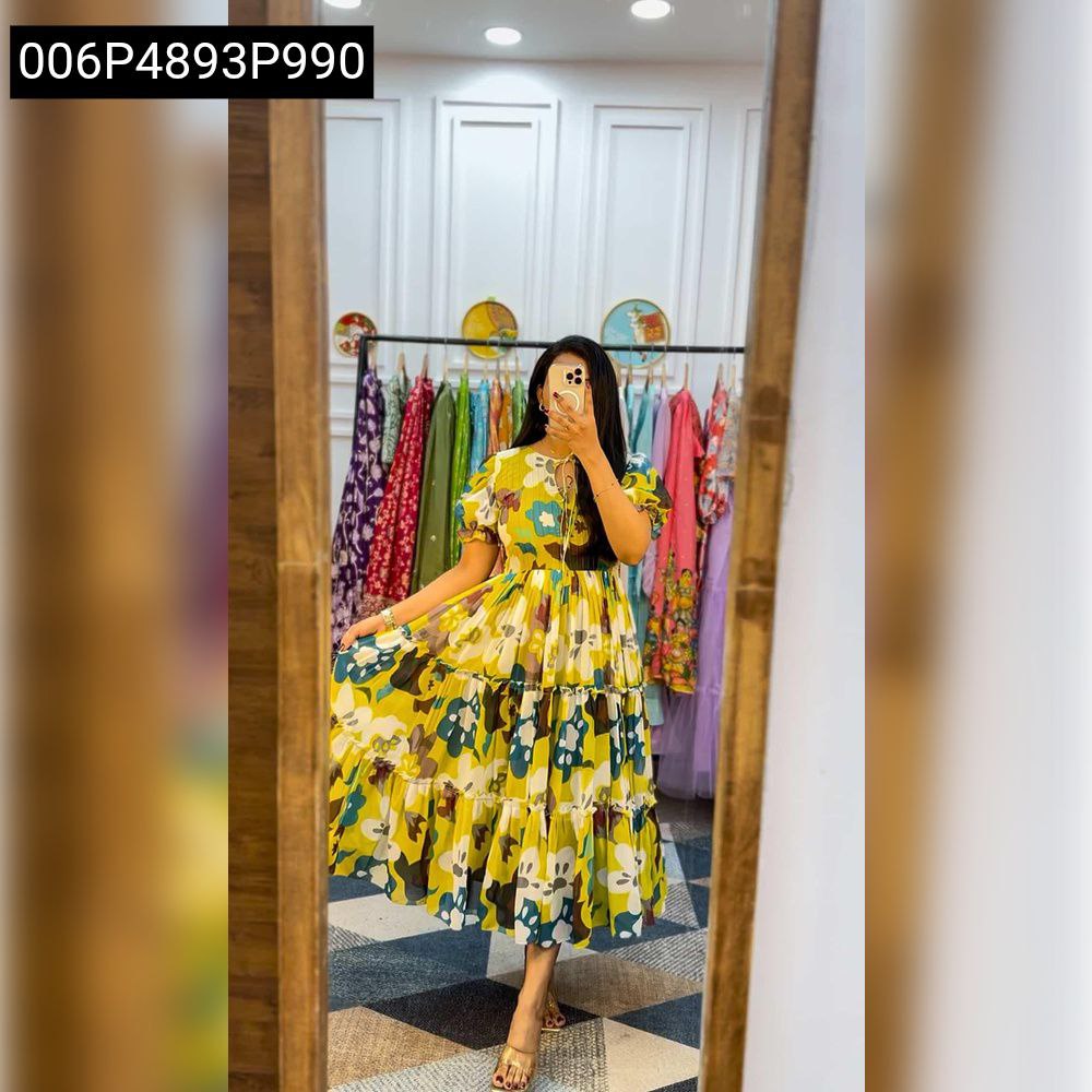 Model wearing a yellow multi-floral georgette tiered maxi dress, posing in a mirror