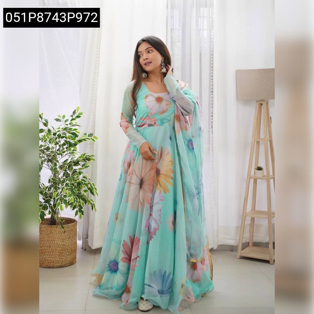 Woman posing gracefully in an aqua floral organza gown with dupatta indoors, showcasing full ensemble.