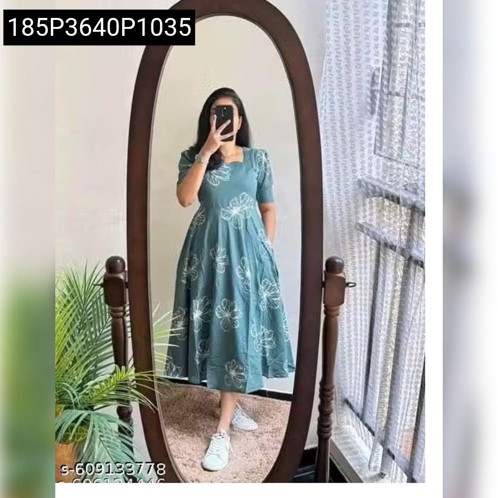 Woman posing in a teal blue floral print flared cotton dress, full body mirror shot.