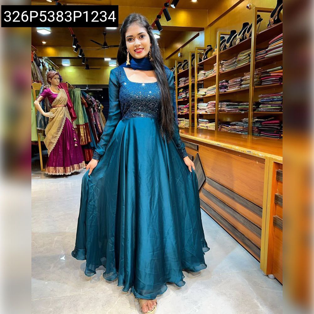 Full body shot of model wearing Teal Blue Georgette Anarkali Suit with dupatta, posing in a boutique.