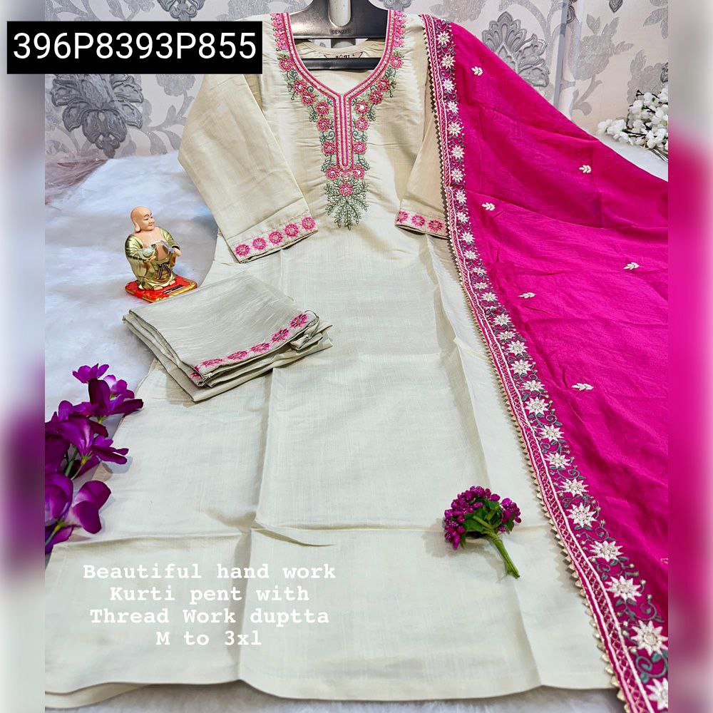 Full view of light beige hand-work kurti with hot pink dupatta and pants, with flowers and a small statue.