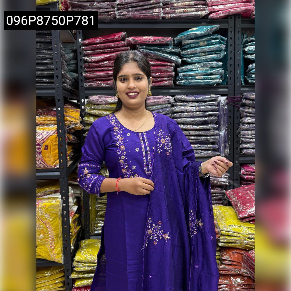Model wearing a Royal Purple hand-embroidered Viscose kurti set with matching dupatta and pants, standing in a textile store.