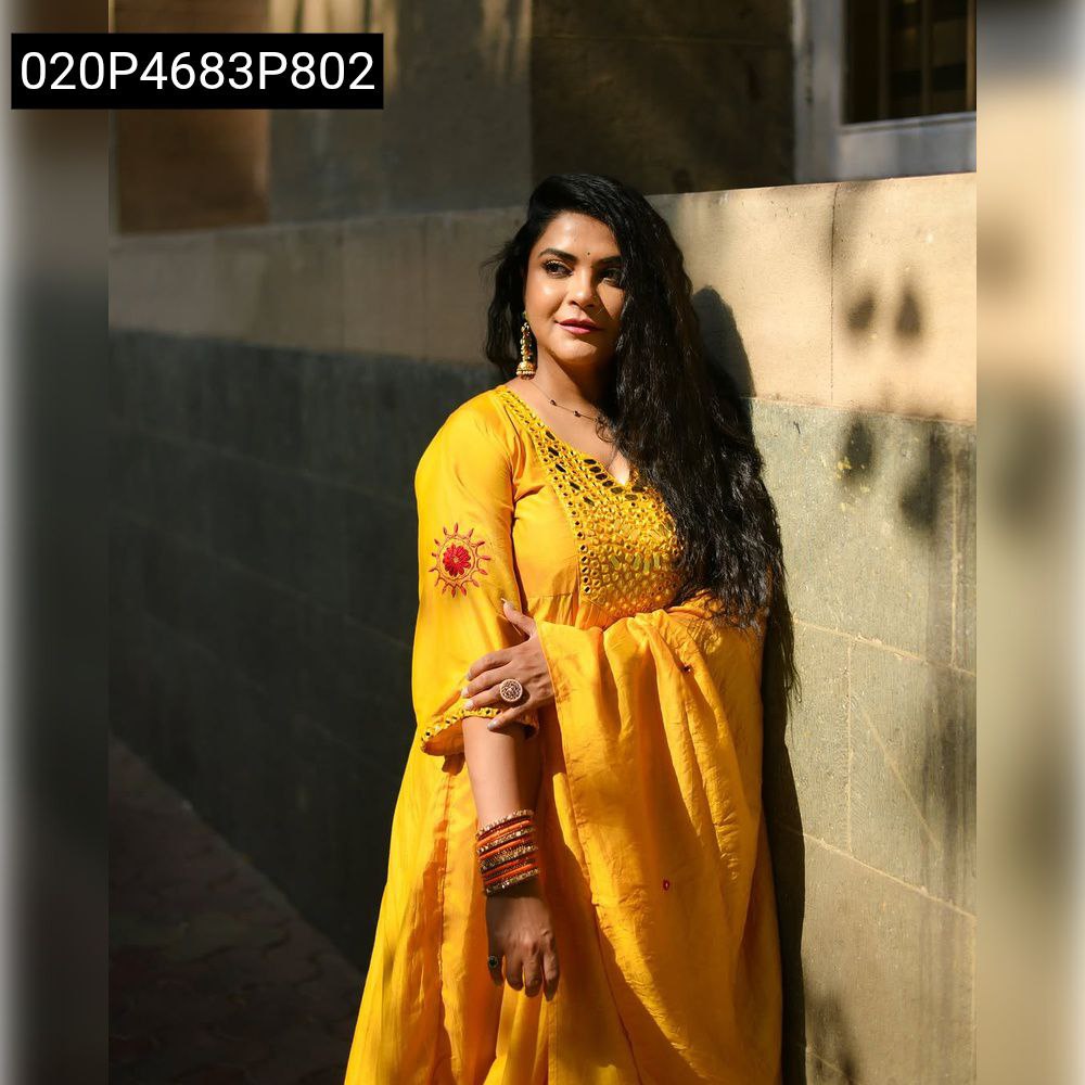Full body shot of a woman in a yellow mirror work kurti set, posing outdoors, showcasing the flared design.