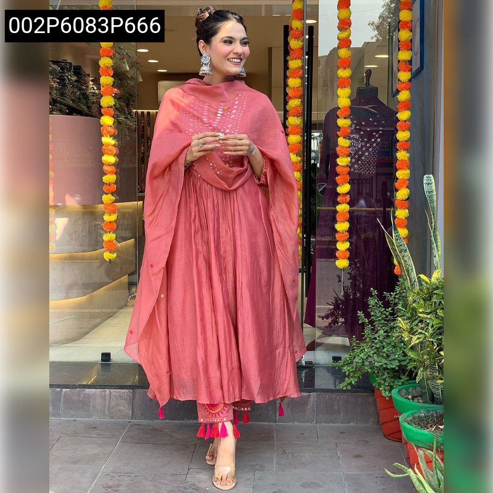 Model in pinkish-red Masleen cotton mirror work kurti set, smiling gracefully outside a store.