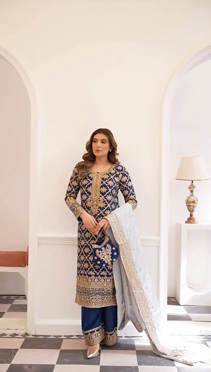 Front-facing model shot showcasing the navy blue embroidered ethnic set indoors.
