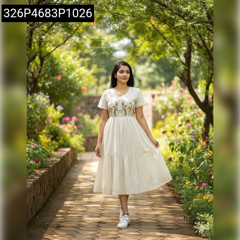 Woman walking in a garden, wearing a Cream Cora Cotton patch embroidered maxi dress, highlighting its comfortable fit and style.