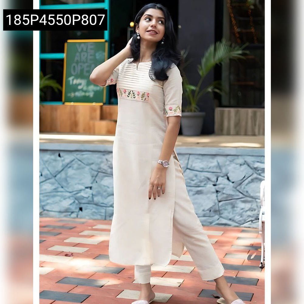 Woman posing in a cream premium cotton kurti pant set with cross embroidery, front view.