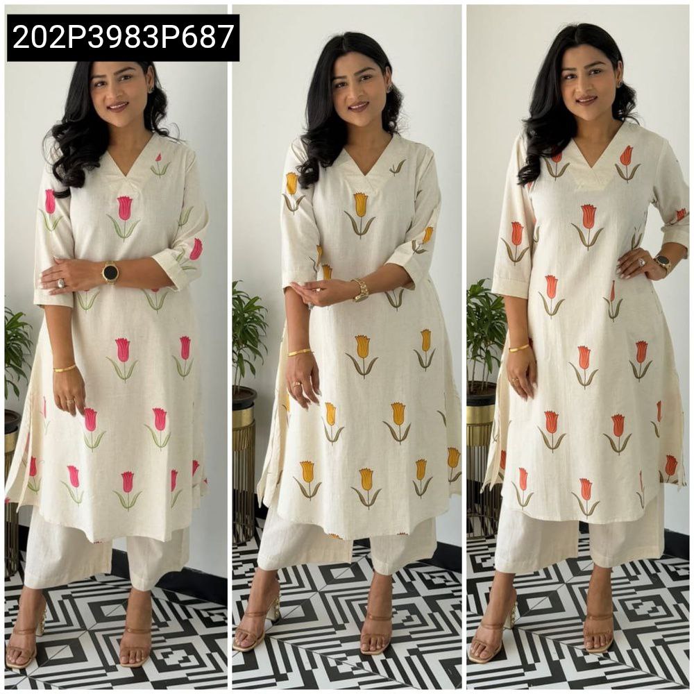 Woman posing in a cream cotton co-ord set with coral tulip prints, straight fit top and ankle-length pants.