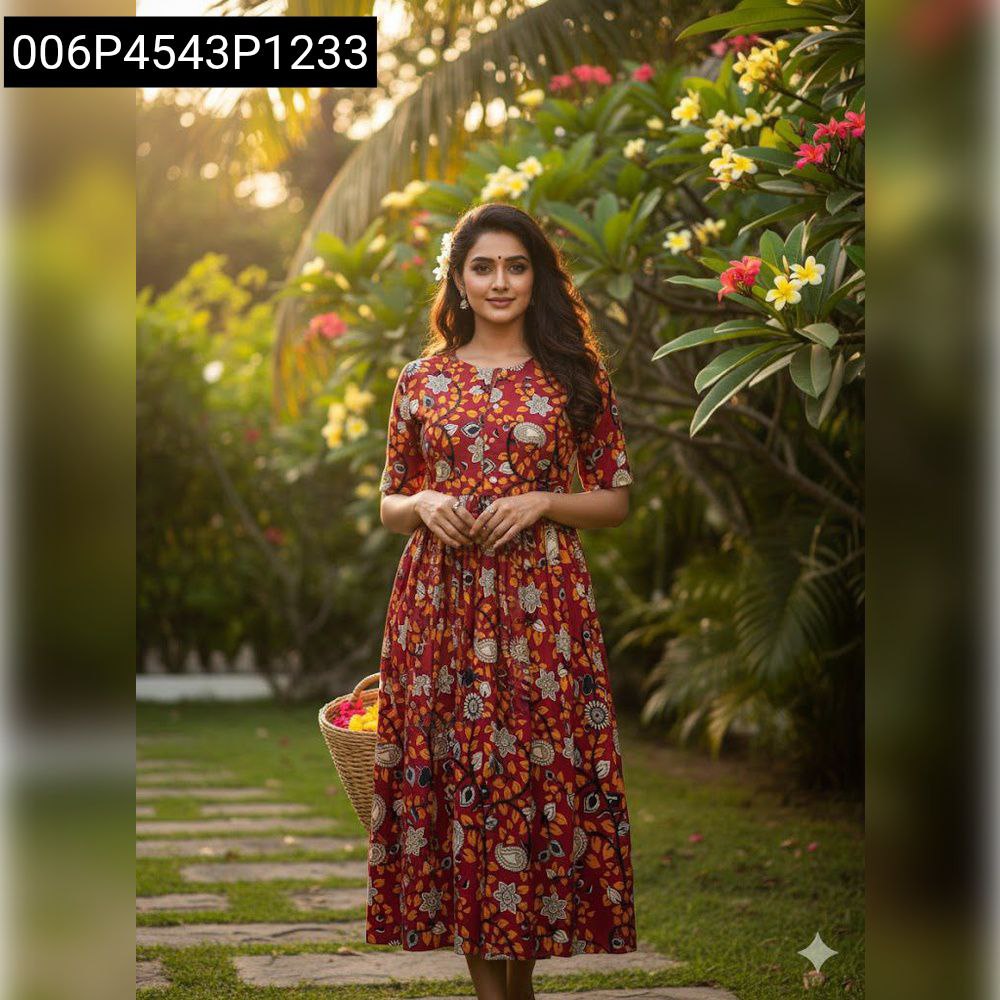 Woman in a red soft cotton maxi dress with floral and paisley print, walking through a serene garden path.