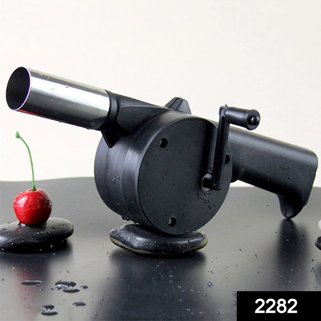 Person uses 2282 portable hand crank air blower fan to ignite charcoal grill for BBQ